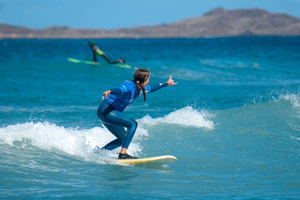A surf school student who surfs her first green wave