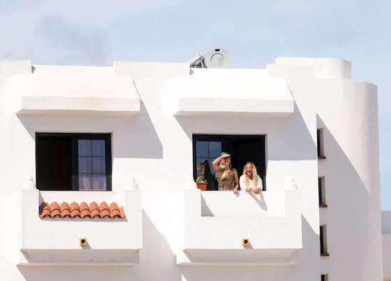 Two surf students stand on the balcony of the surf school in Fuerteventura