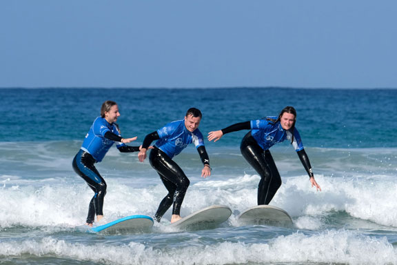 Surfschüler in Moliets zu dritt beim Wellenreiten