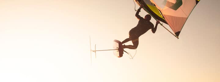 Surfer während einem Luftsprung beim Wing Foiling