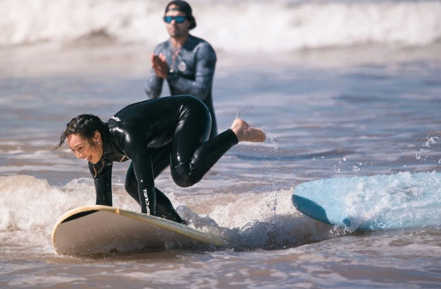 Wipeout of a surf student on her first wave riding attempts